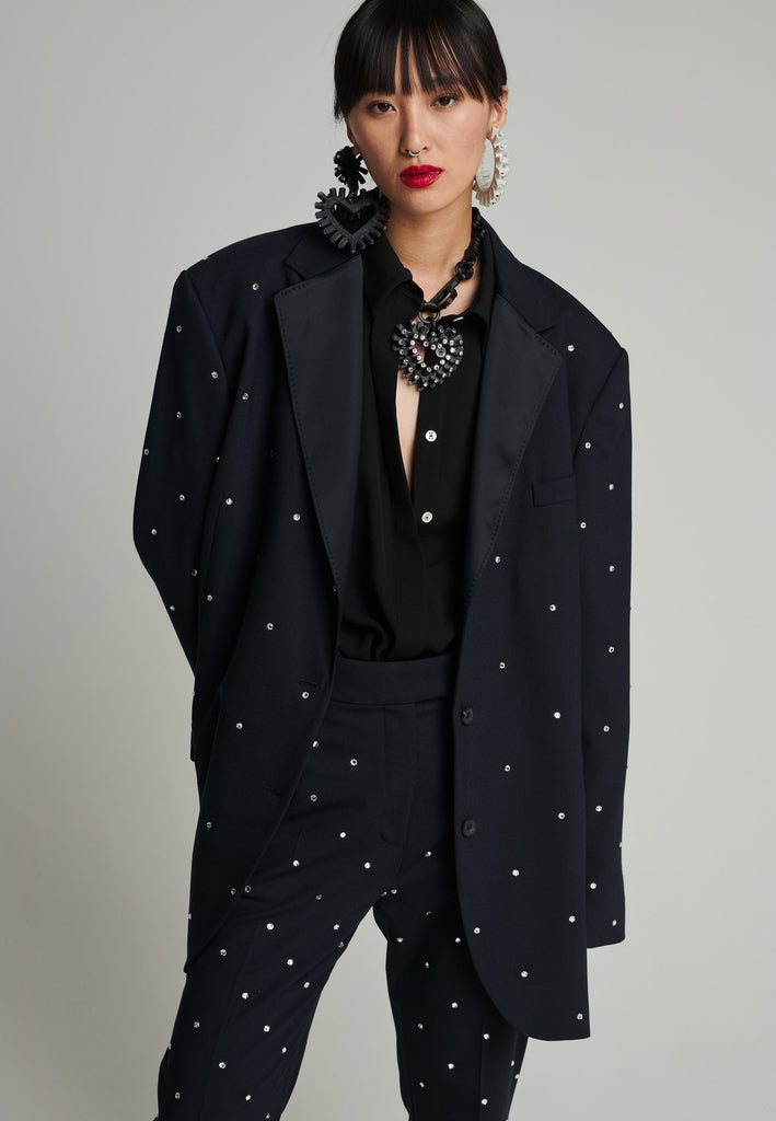 Wide-shouldered blazer in navy. Features sprinkled Swarovski diamonds, shoulder pads, pockets, and exaggerated long sleeves. Fits super oversize.