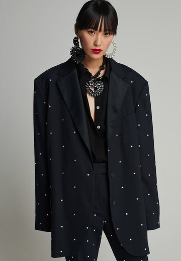 Wide-shouldered blazer in navy. Features sprinkled Swarovski diamonds, shoulder pads, pockets, and exaggerated long sleeves. Fits super oversize.