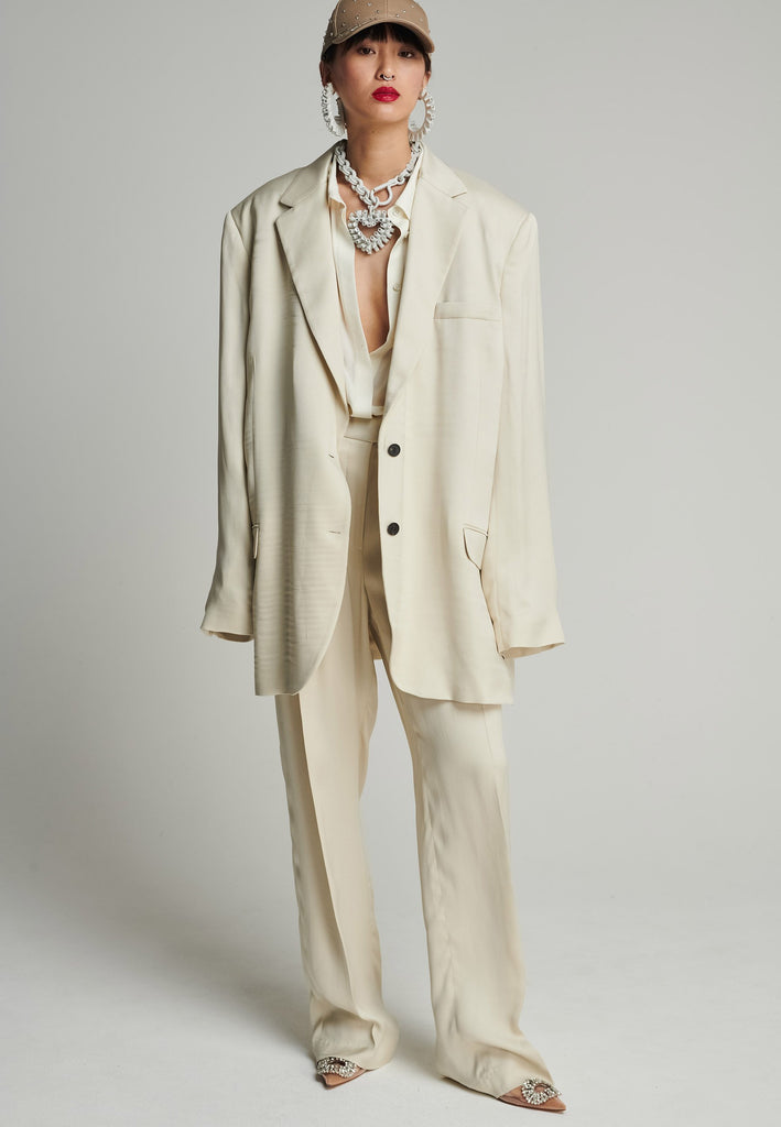 Wide-shouldered striped satin blazer in stone Features shoulder pads, pockets, and exaggerated long sleeves. Fits super oversize.