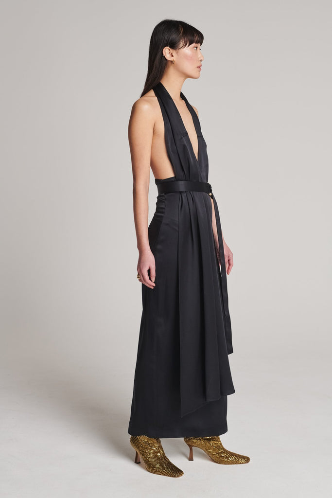 Asymmetric maxi halter dress in satin crepe. Features asymmetric details, a long right panel, a back slit and an adjustable belt with a silver and gold buckle. True to size.