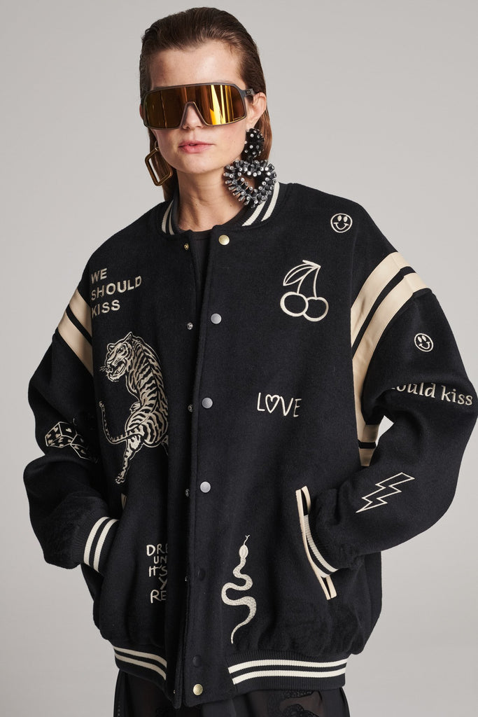 Wide-shouldered baseball jacket. Features unique designs all-over, stamped logo on the back, press buttons, leather shoulder straps, pockets, elasticated cuffs and waistband. Fits oversized.