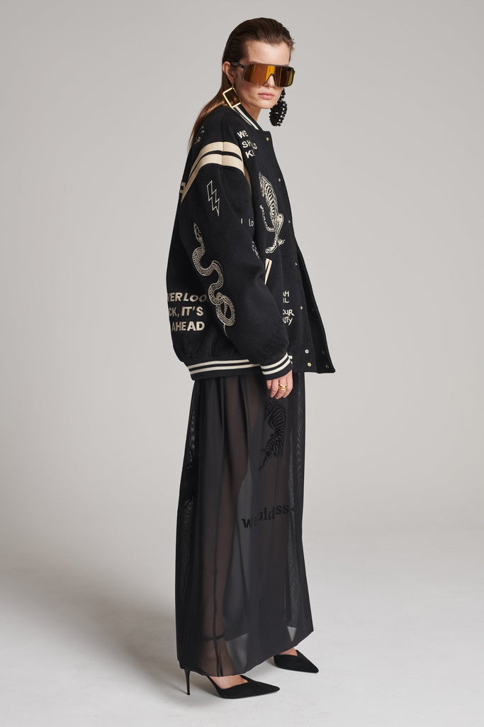 Wide-shouldered baseball jacket. Features unique designs all-over, stamped logo on the back, press buttons, leather shoulder straps, pockets, elasticated cuffs and waistband. Fits oversized.