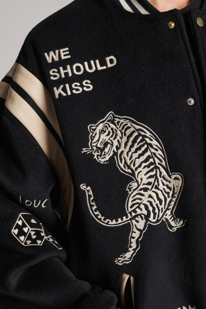 Wide-shouldered baseball jacket. Features unique designs all-over, stamped logo on the back, press buttons, leather shoulder straps, pockets, elasticated cuffs and waistband. Fits oversized.