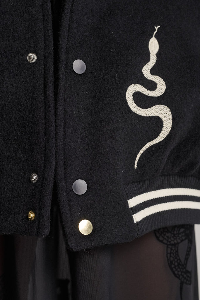 Wide-shouldered baseball jacket. Features unique designs all-over, stamped logo on the back, press buttons, leather shoulder straps, pockets, elasticated cuffs and waistband. Fits oversized.