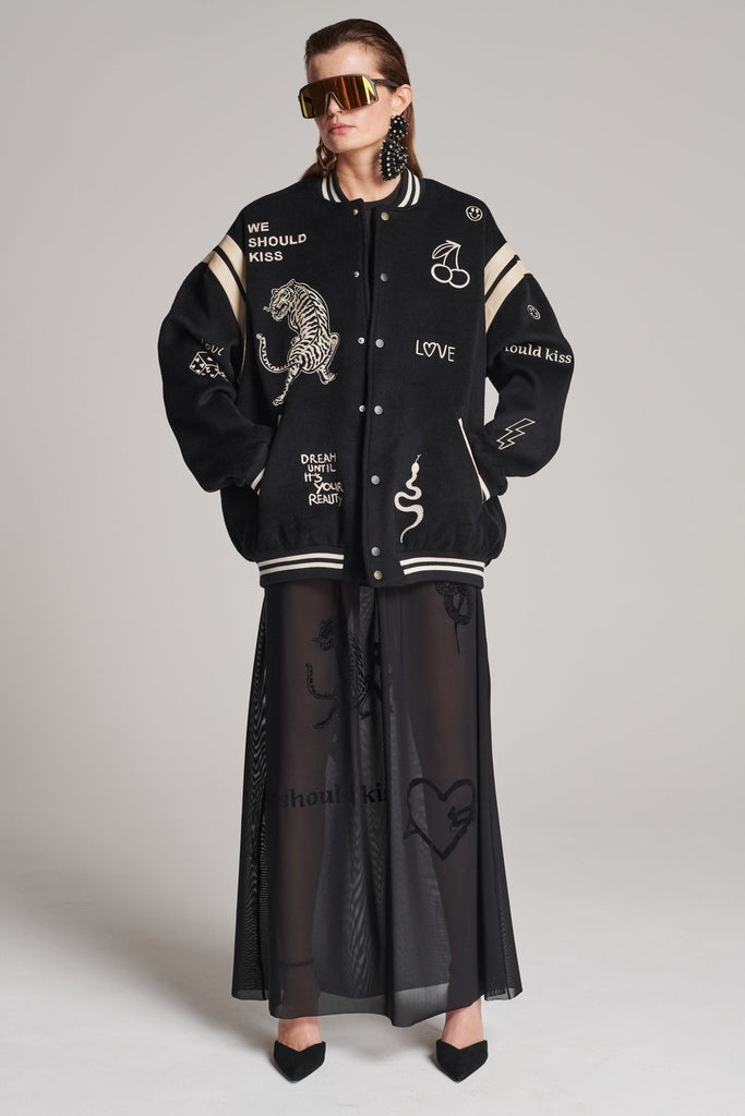 Wide-shouldered baseball jacket. Features unique designs all-over, stamped logo on the back, press buttons, leather shoulder straps, pockets, elasticated cuffs and waistband. Fits oversized.