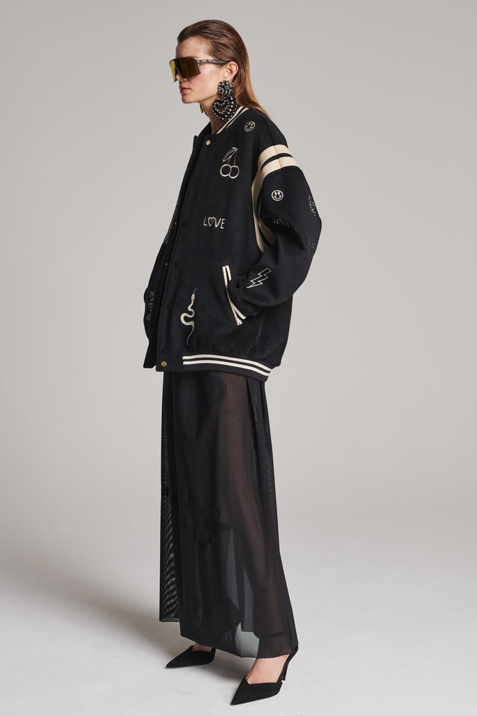 Wide-shouldered baseball jacket. Features unique designs all-over, stamped logo on the back, press buttons, leather shoulder straps, pockets, elasticated cuffs and waistband. Fits oversized.