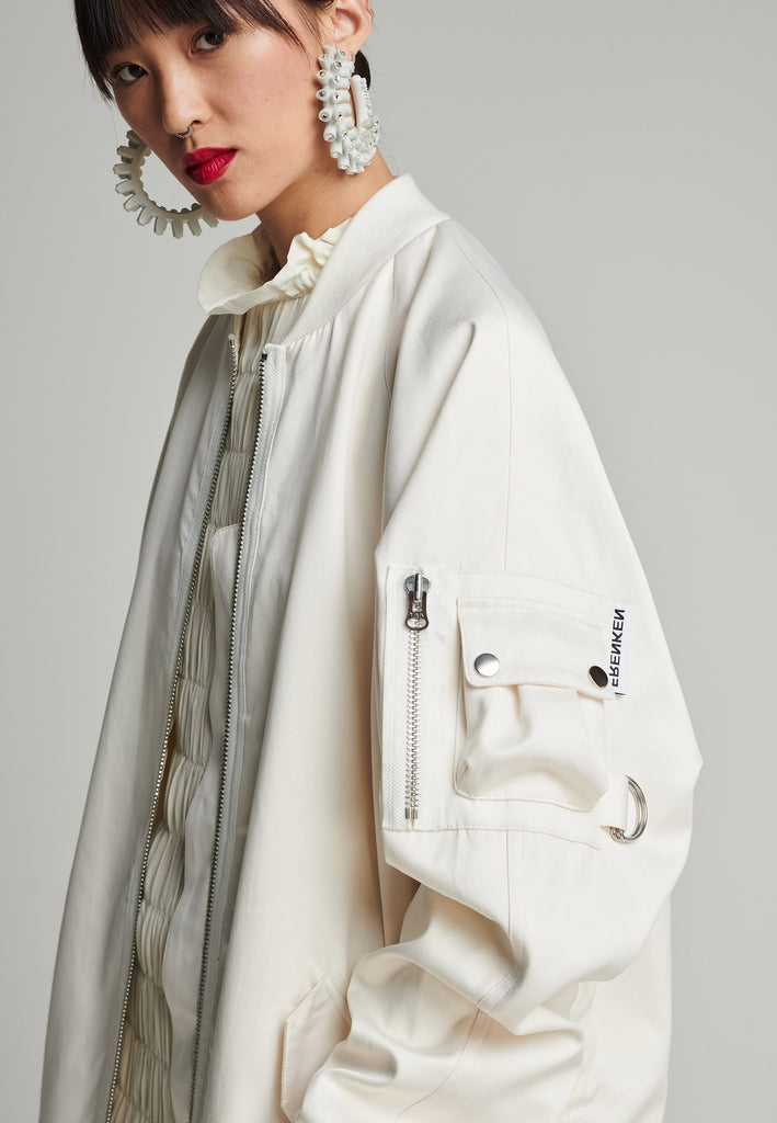 Satin bomber in off-white. Features batwing sleeves, front and arm pockets, zipper closure, and an wrinkled effect on the back. Fits oversize.