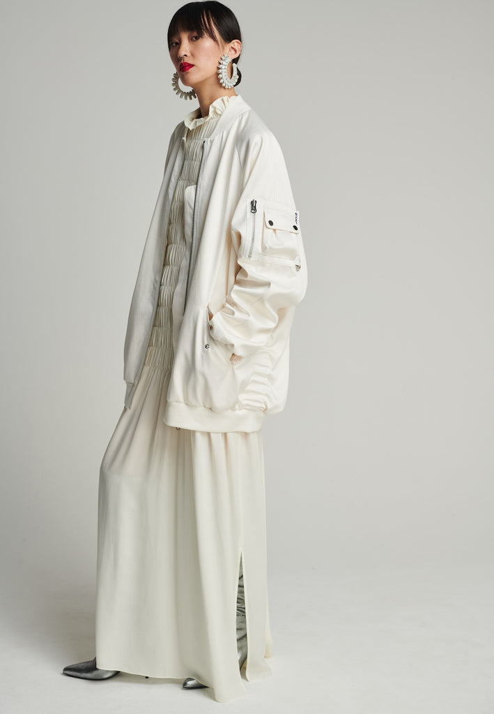 Satin bomber in off-white. Features batwing sleeves, front and arm pockets, zipper closure, and an wrinkled effect on the back. Fits oversize.