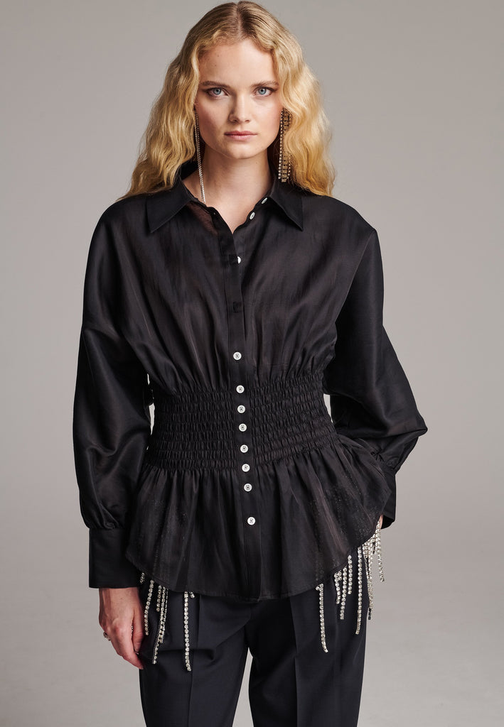Gathered into a waistline defined by shirring elastic which opens out again into a softly draping peplum hem.